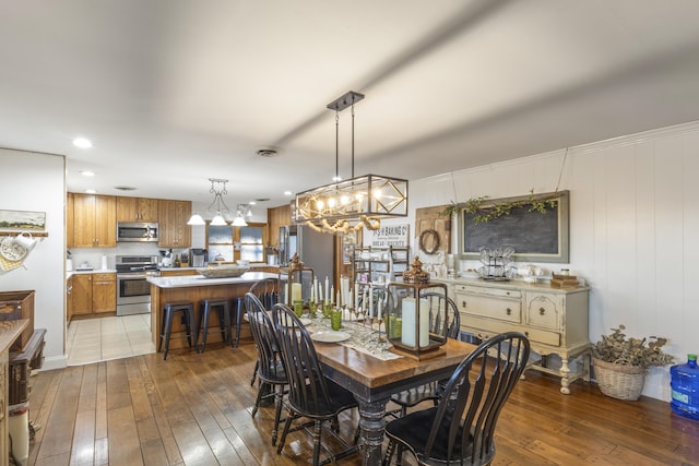 dining space featuring a notable chandelier, dark hardwood / wood-style floors, and wood walls