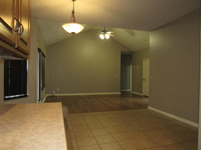 unfurnished living room with dark hardwood / wood-style flooring, ceiling fan, and lofted ceiling