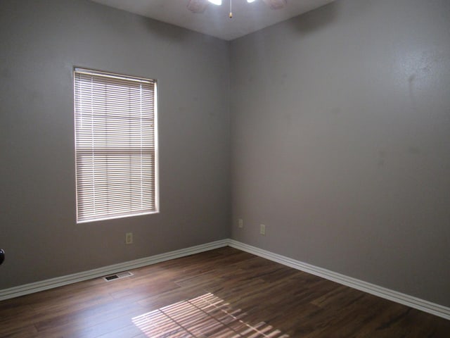 spare room with ceiling fan and dark wood-type flooring