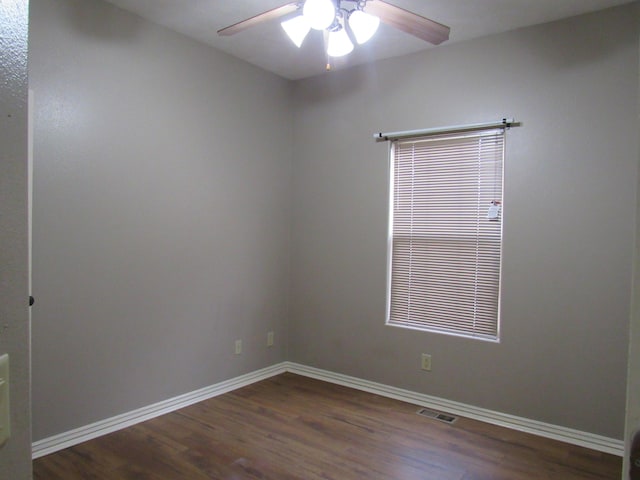 empty room featuring dark hardwood / wood-style flooring and ceiling fan