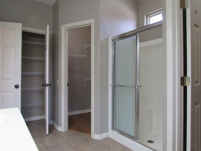 bathroom featuring tile patterned floors and a shower with shower door