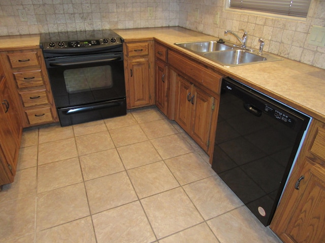 kitchen with black appliances, backsplash, light tile patterned floors, and sink