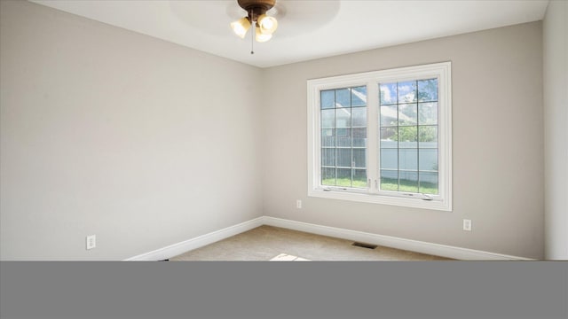 carpeted empty room featuring plenty of natural light and ceiling fan