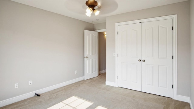 unfurnished bedroom with ceiling fan, light colored carpet, and a closet