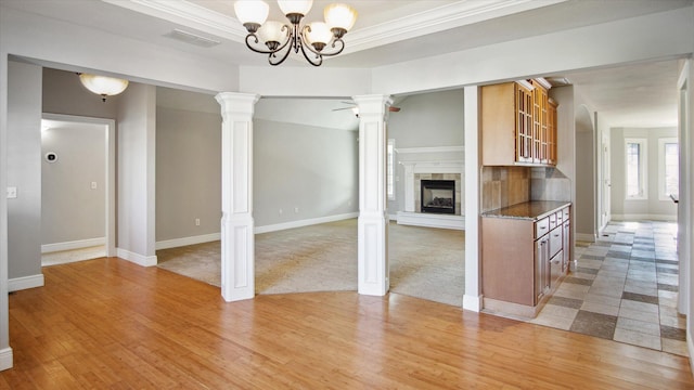 kitchen featuring dark stone counters, crown molding, light hardwood / wood-style floors, and a notable chandelier