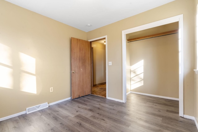 unfurnished bedroom with hardwood / wood-style floors and a closet