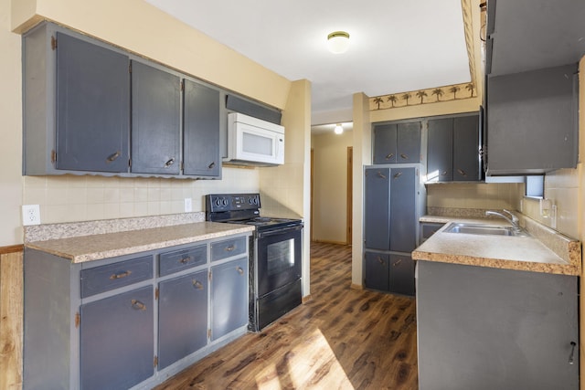 kitchen featuring dark hardwood / wood-style floors, black electric range oven, tasteful backsplash, and sink