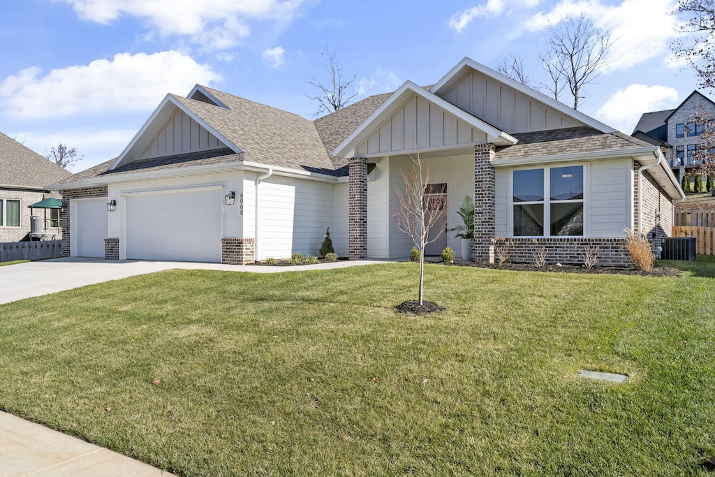 view of front of house with an attached garage, brick siding, concrete driveway, board and batten siding, and a front yard