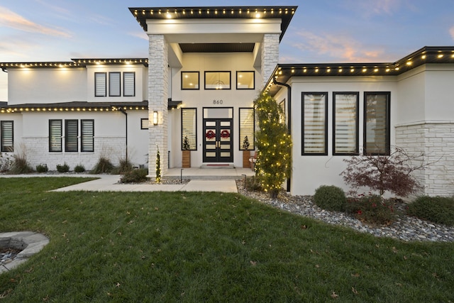 view of front of house featuring french doors and a lawn