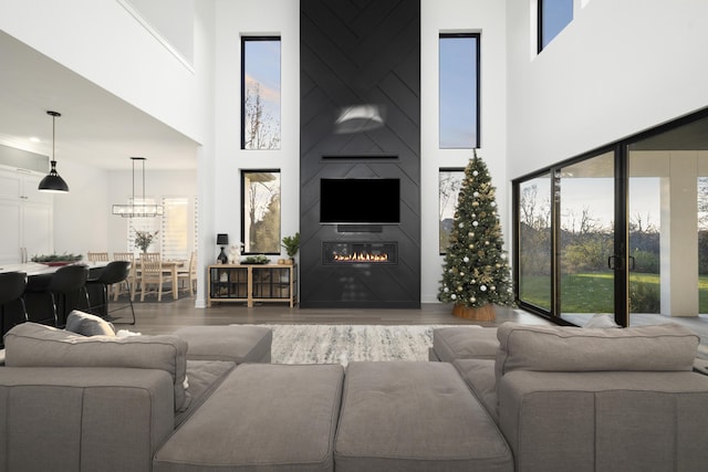 living room with hardwood / wood-style floors, a large fireplace, and a towering ceiling