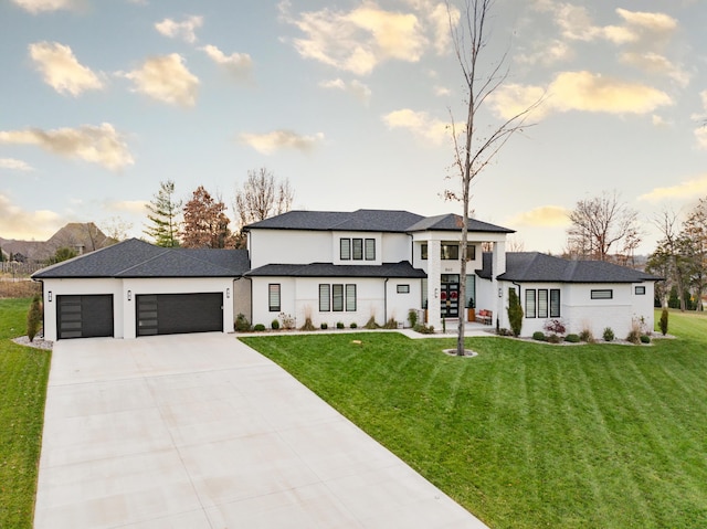 view of front of property with a garage and a lawn