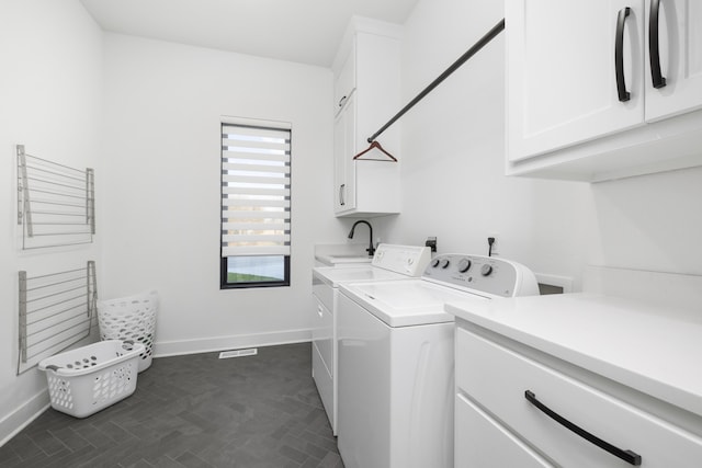 laundry room featuring cabinets, sink, and washing machine and dryer