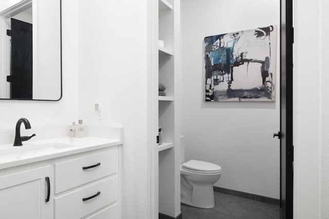 bathroom featuring vanity, toilet, and built in features