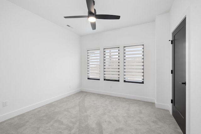 carpeted spare room featuring ceiling fan