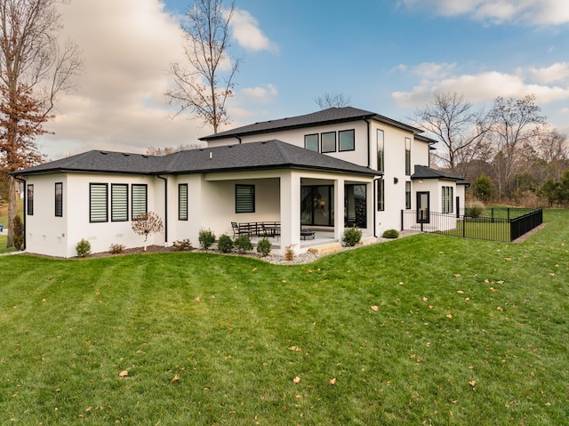 back of house with a lawn and a patio