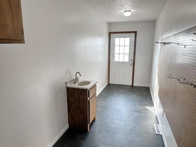 doorway featuring sink and a textured ceiling