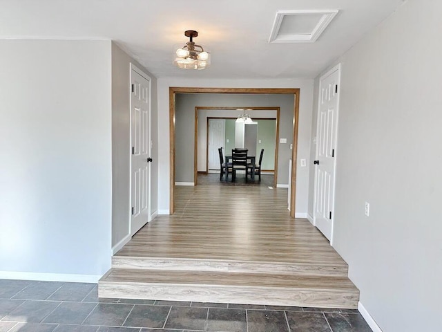 corridor featuring hardwood / wood-style floors and a notable chandelier