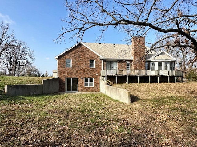 back of house featuring a lawn and a wooden deck