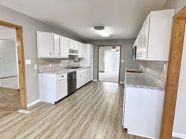 kitchen with light stone countertops, light wood-type flooring, tasteful backsplash, dishwasher, and white cabinets