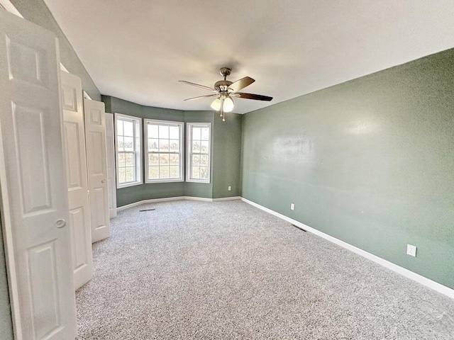 carpeted empty room featuring ceiling fan