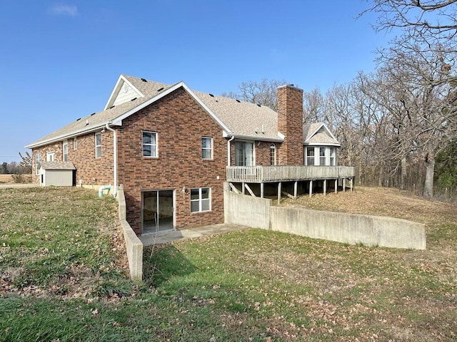 back of property featuring a wooden deck and a yard