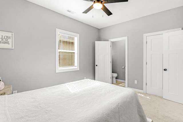 carpeted bedroom with connected bathroom and ceiling fan