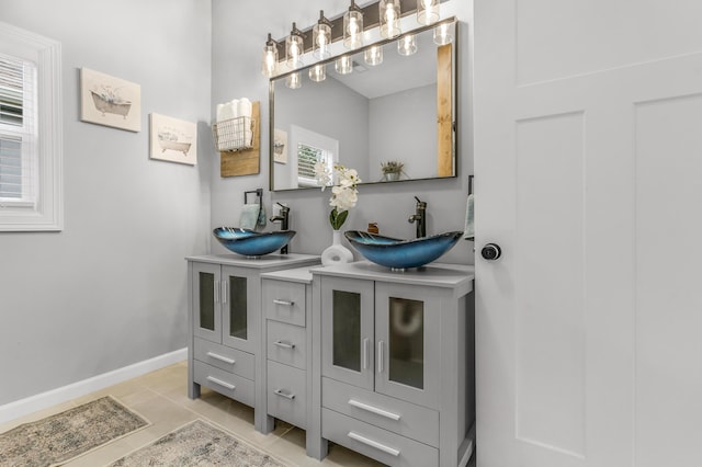 bathroom with tile patterned flooring, vanity, and a healthy amount of sunlight