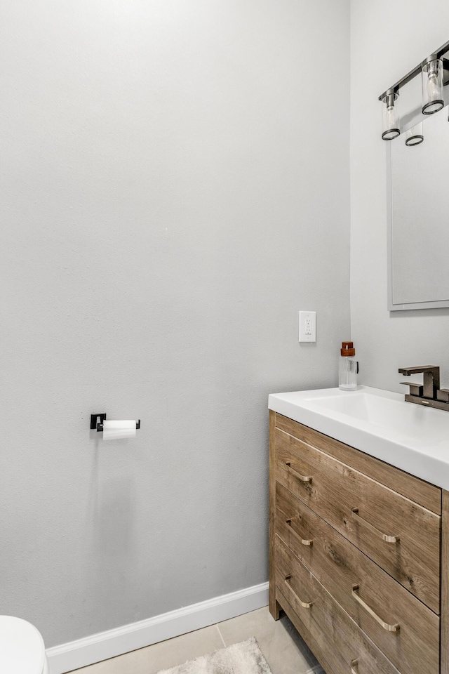 bathroom with tile patterned flooring, vanity, and toilet