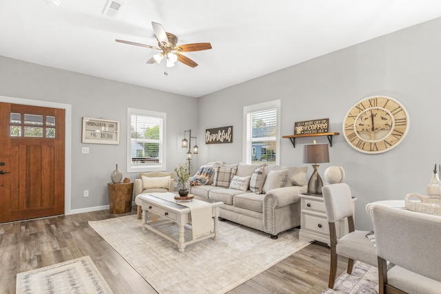 living room featuring ceiling fan, a wealth of natural light, and light hardwood / wood-style flooring