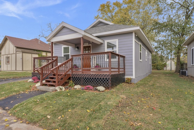 view of front facade featuring central AC, a front lawn, and a wooden deck