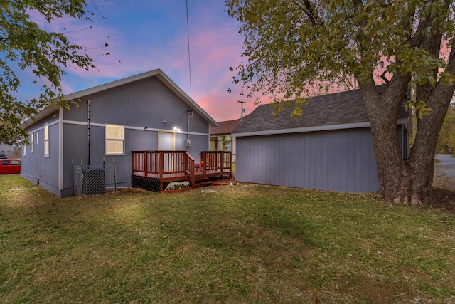 back house at dusk with a yard, a deck, and cooling unit