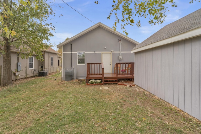 rear view of property featuring a lawn and a deck