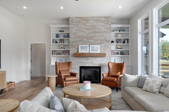 living room with a large fireplace and light hardwood / wood-style flooring