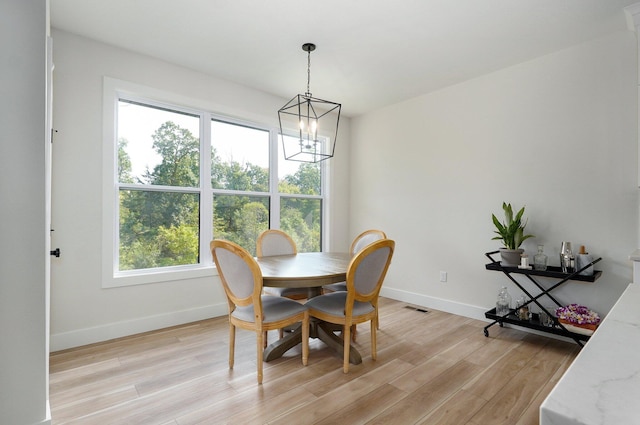 dining area with a chandelier, a healthy amount of sunlight, and light wood-type flooring