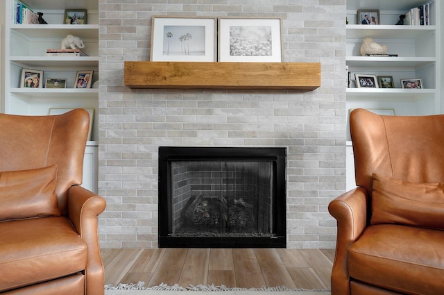 living area with built in shelves and wood-type flooring