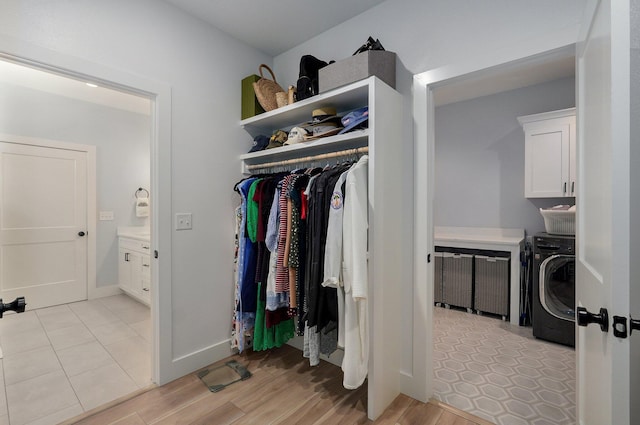 spacious closet featuring light hardwood / wood-style flooring and washer / dryer