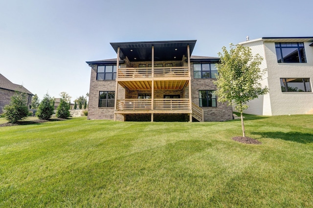 rear view of house with a balcony and a yard