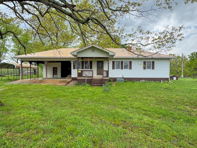 back of house featuring metal roof, covered porch, cooling unit, a lawn, and a chimney