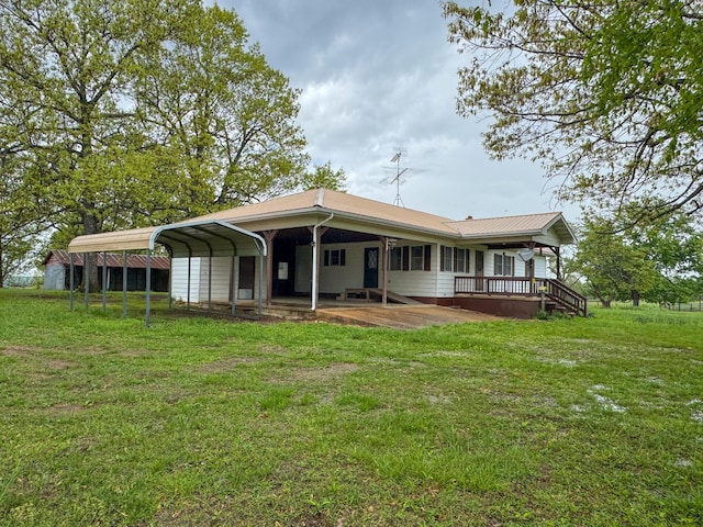 back of property featuring a lawn and a carport