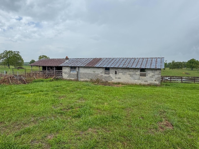 view of yard featuring fence, an exterior structure, and an outbuilding