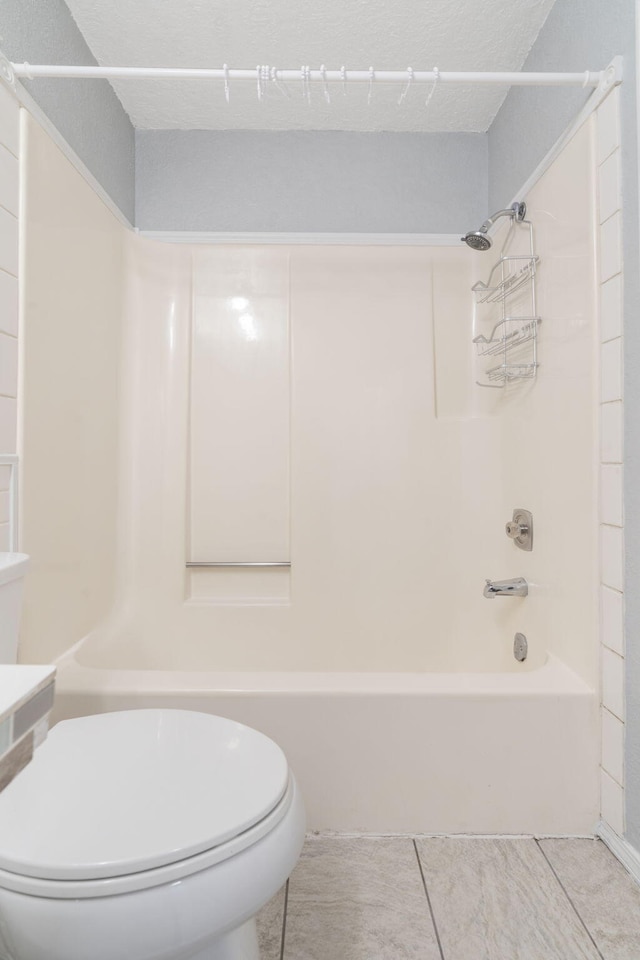 bathroom featuring tile patterned floors, shower / washtub combination, and toilet