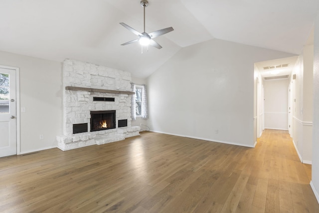 unfurnished living room with ceiling fan, a fireplace, hardwood / wood-style floors, and vaulted ceiling