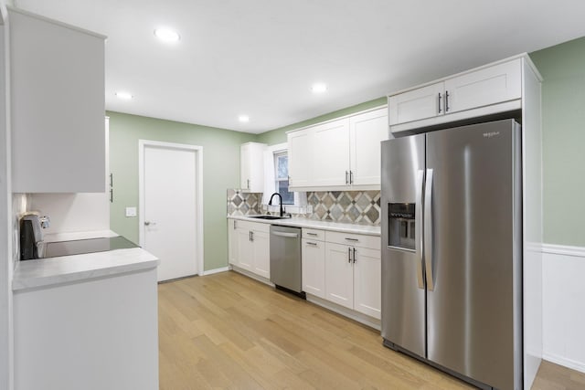 kitchen featuring appliances with stainless steel finishes, backsplash, white cabinetry, and sink