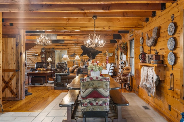 dining area with beam ceiling, light wood-type flooring, rustic walls, and an inviting chandelier