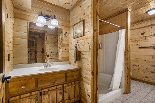 bathroom featuring vanity, curtained shower, and wood walls