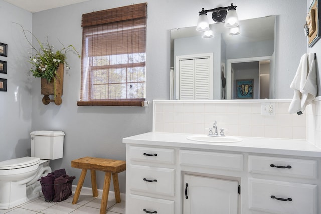 bathroom featuring tile patterned floors, toilet, vanity, and backsplash