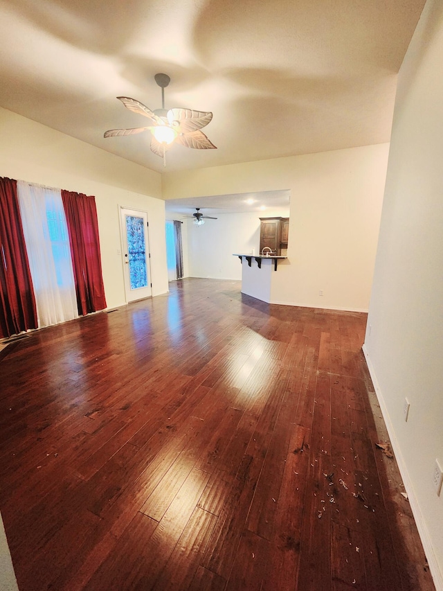 unfurnished room with ceiling fan and dark wood-type flooring