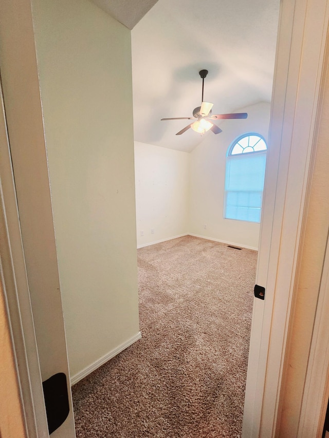 unfurnished room with carpet flooring, vaulted ceiling, and ceiling fan