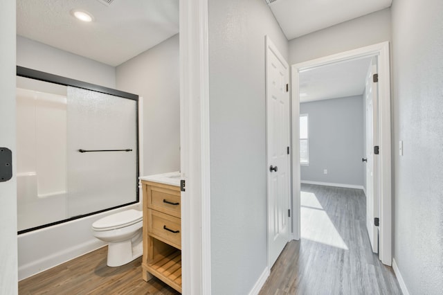 full bathroom featuring enclosed tub / shower combo, vanity, wood-type flooring, and toilet