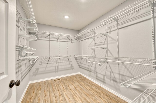 spacious closet with hardwood / wood-style floors